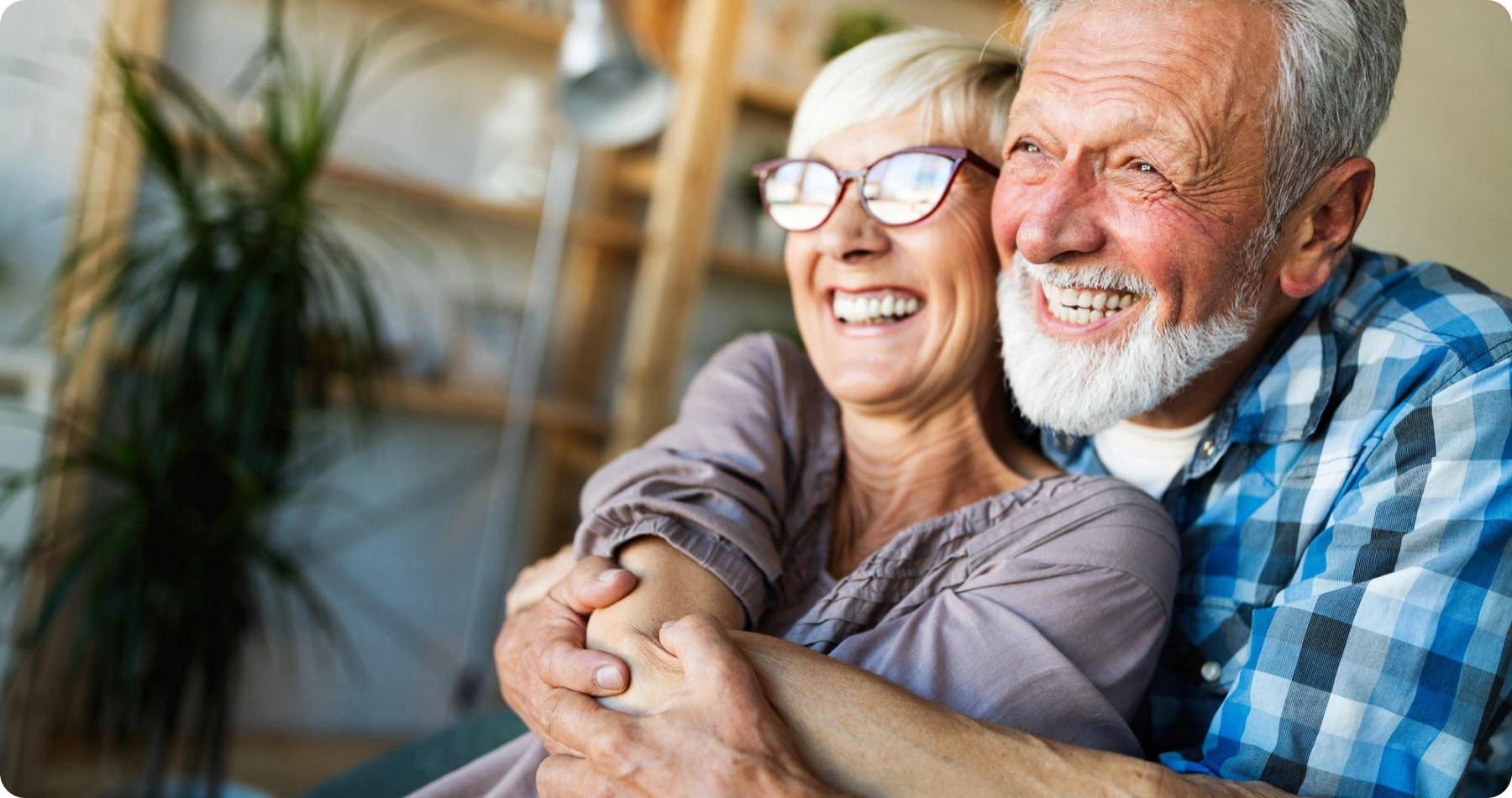 Happy couple hugging after dental implants treatment.