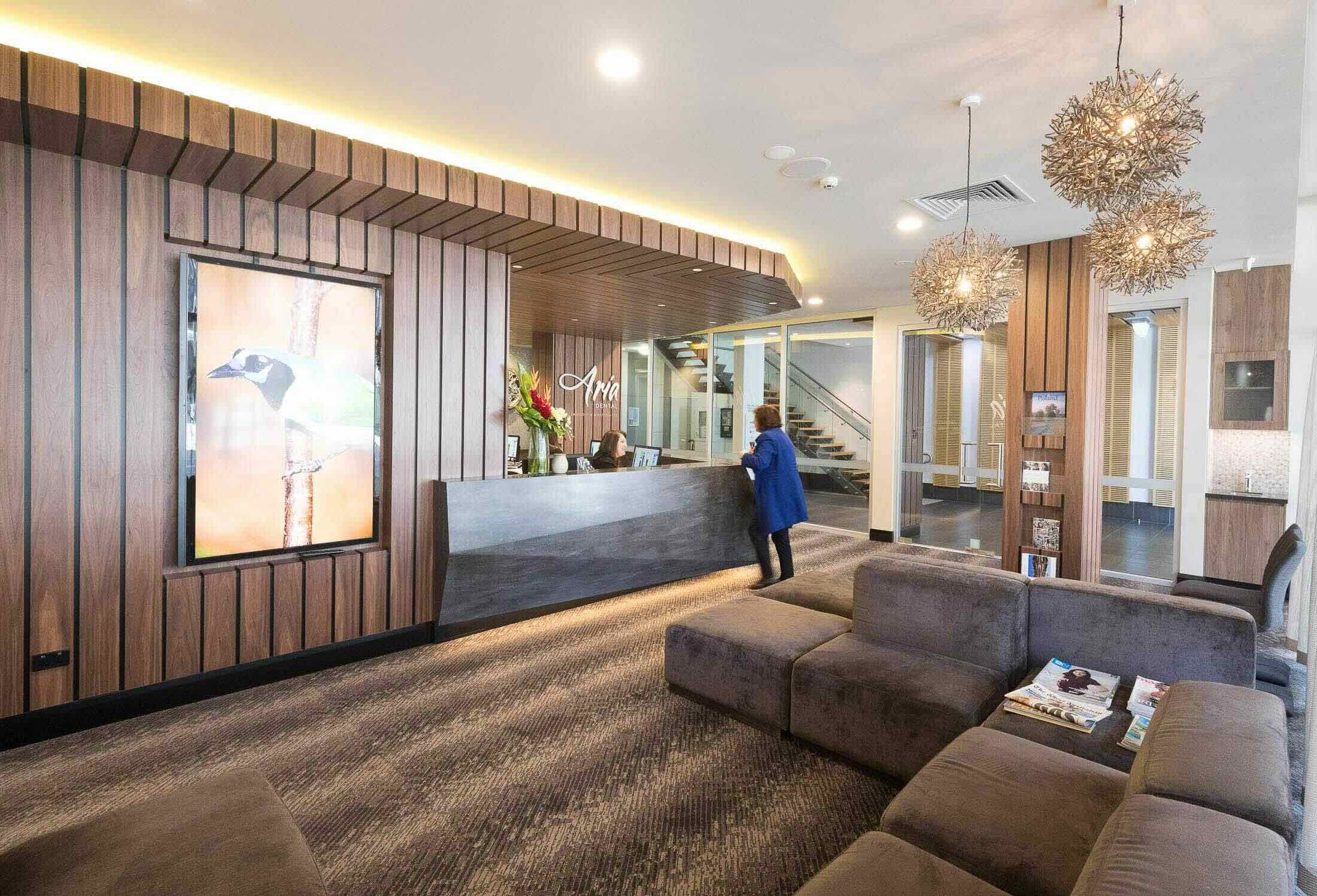 Patient enquiring about gum set ceramic bridge at aria dental reception.